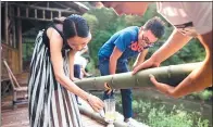  ??  ?? A tourist in Yibin tries Wuliangye, a white spirit injected into live bamboo trunks as an unconventi­onal aging technique.