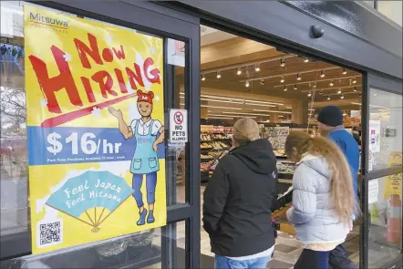  ?? AP file photo ?? A hiring sign is displayed at a grocery store in Arlington Heights, Ill. on Jan. 13. A strong job market has helped fuel the inflation pressures that have led the Federal Reserve to keep raising interest rates.