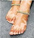  ??  ?? PATTERNS: The bride shows off her hennaed feet