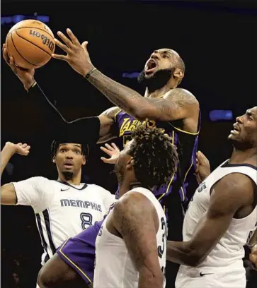  ?? Luis Sinco Los Angeles Times ?? LeBRON JAMES drives to the basket between a trio of Memphis Grizzlies defenders. James scored 32 points, but the Lakers faded in fourth in another disappoint­ing loss, of which James said, “We just suck right now.”