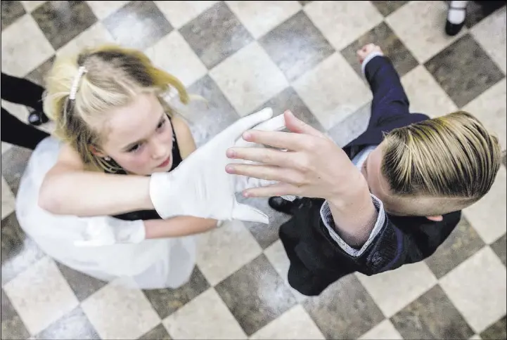  ??  ?? Brynlie Hannig, left, dances with Lennon Wever during the final night of cotillion — a social education program — at Vistas Community Center in Summerlin.