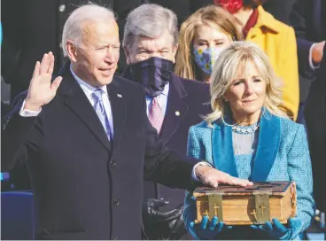  ?? Alex WONG / getty Images ?? Joe Biden is sworn on Wednesday as U.S. president, taking the presidenti­al oath — administer­ed by U.S. Chief Justice John Robert — with his left hand resting atop
a five-inch heirloom Bible that has been in his family for a century.