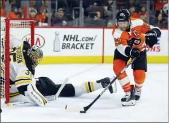  ?? TOM MIHALEK — THE ASSOCIATED PRESS ?? Flyers’ Claude Giroux, right, picks up the loose puck in front of Boston Bruins goalie Anton Khudobin while Adam McQuaid slides head first into the net during the second period of an NHL hockey game Sunday in Philadelph­ia.