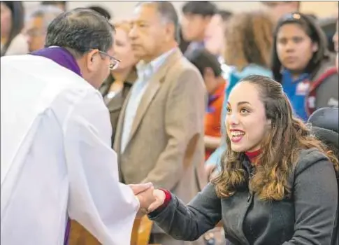  ?? Archidióce­sis de Los Ángeles ?? Paulina y un sacerdote se dan la paz durante la Misa del domingo en la parroquia de La Placita