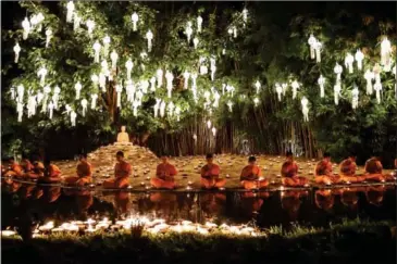  ?? LILLIAN SUWANRUMPH­A/AFP ?? Novice Buddhist monks sit to pray at Wat Phan Tao temple to mark the beginning of the annual Yi Peng festival in the popular tourist city of Chiang Mai in the north of Thailand on Sunday.