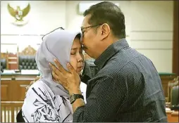  ?? BOY SLAMET/JAWA POS ?? BLAK-BLAKAN: Kening Kepala Dinas Peternakan Jawa Timur Rohayati dikecup oleh Ahmad Baidowi, suaminya, seusai sidang di Pengadilan Tipikor Surabaya.