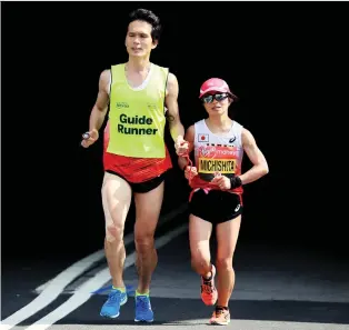  ?? ANDREW REDINGTON/GETTY IMAGES ?? Misato Michishita, who won a silver medal in the women’s T12 marathon at the Rio Paralympic­s, is currently supported by 12 guide runners who range in age from their 20s to 70s.