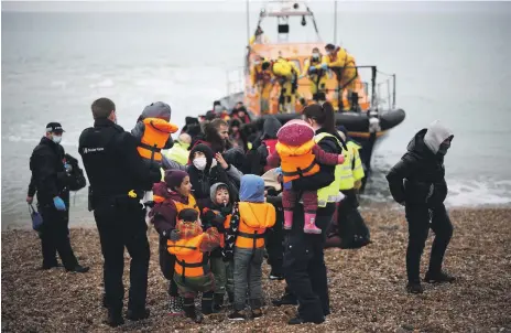  ?? Reuters ?? Migrants are brought ashore to the UK by lifeboat staff, police and Border Force officers, after having crossed the Channel