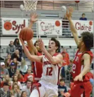  ?? PAUL DICICCO — THE NEWS-HERALD ?? Perry’s Jake Reid shoots past Harvey’s Desmond Taylor on Feb. 27 at Perry.