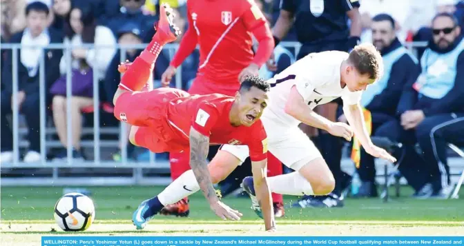  ??  ?? WELLINGTON: Peru’s Yoshimar Yotun (L) goes down in a tackle by New Zealand’s Michael McGlinchey during the World Cup football qualifying match between New Zealand and Peru at Westpac Stadium in Wellington yesterday. — AFP