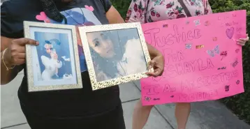  ?? BILLY SCHUERMAN/STAFF FILE ?? Elisheba Harris, left, holds photos of her daughter, Deshayla Harris, with Rachel Walker outside Virginia Beach City Hall in 2022. Deshayla Harris was killed in Virginia Beach in March 2021.