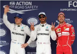  ??  ?? Lewis Hamilton (centre) poses with Valtteri Bottas (left) and Sebastian Vettel after taking pole position for the Japanese Grand Prix at Suzuka on Saturday. —