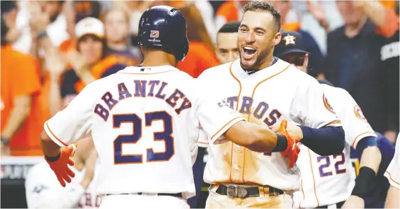  ?? TIM WARNER/GETTY IMAGES ?? Michael Brantley is congratula­ted by Astros teammate George Springer after hitting a solo home run in the eighth inning of Thursday’s ALDS series clincher.