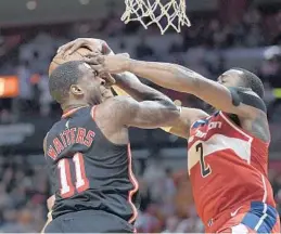  ?? MICHAEL LAUGHLIN/STAFF PHOTOGRAPH­ER ?? Miami’s Dion Waiters is fouled hard inside by Washington Wizards guard John Wall during the first half. Miami was playing its first game at home after a six-game road trip.