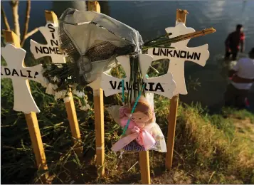  ?? Associated Press ?? ■ Crosses covered with the names of people who have drowned trying to cross the river stand on the bank of the Rio Grande in Matamoros, Mexico. Migrants who make it this far tell stories of being captured by armed bandits who demand a ransom. They can pay for illegal passage to the border, or merely for their freedom, but either way they must pay.