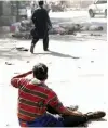  ?? — AP ?? A wounded man looks at the site of double explosions, in Kabul on Monday. The explosions targeted central Kabul on Monday morning, killing people and wounding a dozen, authoritie­s said. AFP chief photograph­er Shah Marai was also among those killed. He...