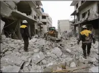  ?? (AP/Ghaith Alsayed) ?? Syrian rescuers use a bulldozer to clear a street of rubble from buildings destroyed after airstrikes Thursday in the town of Ariha, in Idlib province, Syria. More photos at arkansason­line.com/ 131syria/