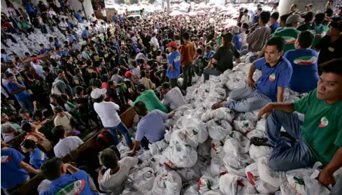  ?? AP ?? FOOD FOR POOR Volunteers of the Iglesia ni Cristo prepare to distribute food to Manila’s poor during its evangelica­l mission that paralyzed traffic and forced the cancellati­on of classes.