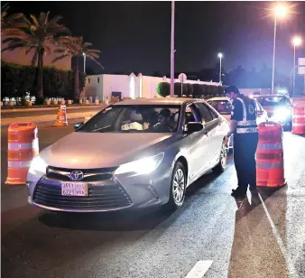  ?? SPA ?? Police enforcing the curfew order check motorists on Sunday. There are currently 27,345 active cases in the Kingdom.