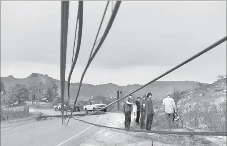  ?? Wally Skalij Los Angeles Times ?? RESIDENTS try to get past a downed power line on Mulholland Highway after the Woolsey fire roared through Malibou Lake on Nov. 10.