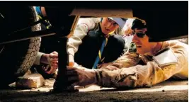  ??  ?? In Kabul, Master Corporal Bill Akerly shows Afghan Scouts how to change a tire.