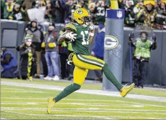  ?? DARRON CUMMINGS / AP ?? The Packers’ Davante Adams runs to the end zone during the second half Sunday. His eight catches for 160 yards and two TDs helped the Packers advance to the NFC championsh­ip game.