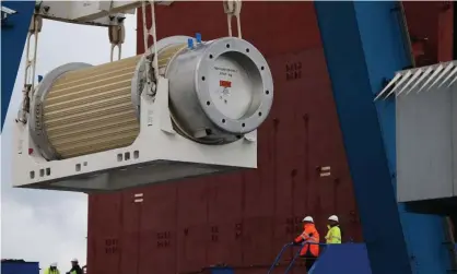  ?? Photograph: Charly Triballeau/AFP/Getty Images ?? A transport storage cask for the return of high activity waste from reprocessi­ng is loaded on to a cargo ship on October 15, 2015 in Cherbourg-Octeville for delivery to Australia after reprocessi­ng in France.