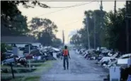  ?? DAVID GOLDMAN — THE ASSOCIATED PRESS FILE ?? A man walks past debris from homes on his street damaged in flooding from Hurricane Harvey in September 2017.