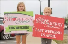  ?? MARK BUFFALO/THREE RIVERS EDITION ?? Avery, 6, and Hunter Conley, 4, hold signs promoting the Cabot Junior Auxiliary Strawberry Festival, which starts Friday in downtown Cabot. The Conleys are the children of Allison Conley, public relations chairwoman for the Strawberry Festival.