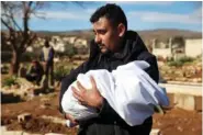  ?? AP PHOTO/GHAITH ALSAYED ?? On Tuesday, a man carries the body of a family member who died in the earthquake that rocked Syria and Turkey at a cemetery in the town of Jinderis, Aleppo province, Syria.