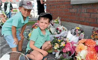  ?? RACHAEL KELLY/STUFF ?? Brothers Innes Fletcher, 3, and Lachie Fletcher, 5, of Heriot, leave flowers and pictures outside the mosque at Mataura yesterday. Left, a small crowd gathered outside the Mataura mosque before going inside to observe two minutes’ silence.