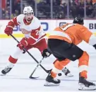  ?? AP ?? The Red Wings’ Dylan Larkin, left, is defended by the Flyers’ Justin Braun during the first period Wednesday in Philadelph­ia.