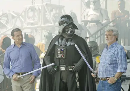  ?? Kent Phillips/disney Parks via Getty Images/files ?? Walt Disney’s chairman and CEO Bob Iger, left, and Star Wars creator George Lucas were at Disney’s Hollywood Studios theme park in Florida together in 2011. Last year, Disney acquired Lucasfilm, the home of Lucas’s Star Wars franchise.