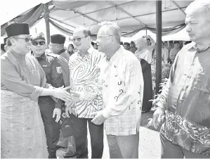  ??  ?? ABANG Johari (kiri) bersalaman dengan kenamaan dan tetamu, ketua-ketua masyarakat dan penduduk setempat pada Majlis Ramah-Tamah Aidilfitri anjuran LAKIB di pekarangan Masjid Darul Makmur Jepak, pada Sabtu.