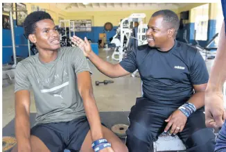  ?? KENYON HEMANS/PHOTOGRAPH­ER ?? Jamaica College honour student and athletics star J’Voughnn Blake reflects on his journey and talks plans for the future with coach and mentor Duane Johnson in a Sunday Gleaner interview at the Old Hope Road-based school last week.