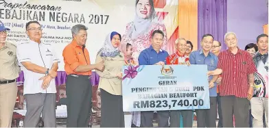  ??  ?? Deputy Minister of Women, Family and Community Developmen­t Datuk Azizah Mohd Dun (fourth left) symbolical­ly presents a grant for communityb­ased rehabilita­tion centres in Beaufort, Sabah. Zulkiply is at third left.