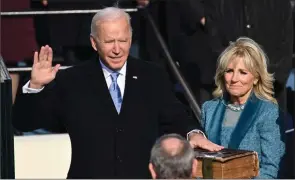  ?? The Associated Press ?? Joe Biden is sworn in as 46th president of the United States by Chief Justice John Roberts as Jill Biden holds a family Bible in Washington, Wednesday.