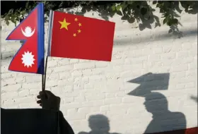  ?? NIRANJAN SHRESTHA — THE ASSOCIATED PRESS ?? A Nepalese man holds Chinese and Nepalese flags as he waits to welcome Chinese president Xi Jinping in Kathmandu, Nepal, Saturday. Xi arrived Saturday from New Delhi, where he met with Indian Prime Minister Narendra Modi. He was received by Nepalese President Bidhya Devi Bhandari and Prime Minister K.P. Sharma Oli at the Kathmandu airport.