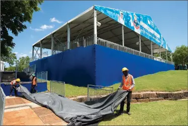  ?? NWA Democrat-Gazette/CHARLIE KAIJO ?? Patrice Openique (from right) of West Palm Beach, Fla., pulls a tarp over a walkway Friday with Exan Cefacile of Fort Pierce, Fla., and Isaiah De Saint-Hillaire of Port St. Lucie, Fla., at Pinnacle Country Club in Rogers. The annual Walmart NW Arkansas Championsh­ip will start today and go until Sunday.