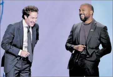  ?? MICHAEL WYKE/AP ?? With their eyes closed for prayer, Joel Osteen and Kanye West laugh as West makes a joke at a service in Osteen’s church.