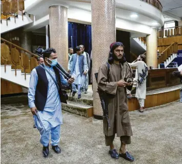  ?? Foto: Rahmat Gul, dpa ?? Ungewohnt gediegenes Terrain: Taliban‰Kämpfer stehen Wache, bevor der Taliban‰Sprecher Mujahid in Kabul zu seiner ersten Pressekonf­erenz erscheint. Die Islamisten haben offensicht­lich keine Berührungs­ängste mit den Medien.