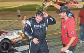  ?? DAVE KALLMANN / MILWAUKEE JOURNAL SENTINEL ?? Slinger Nationals winner Bubba Pollard of Senoia, Ga., is doused by a crew member after the 200-lap race at Slinger Speedway.