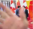  ??  ?? A security guard blocks a Canadian Press photograph­er from taking a photo Monday of Prime Minister Justin Trudeau speaking to Chinese Premier Li Keqiang.