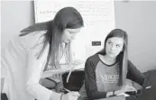  ?? RUSS BYNUM/AP ?? Medical student Catherine Waldron talks with epidemiolo­gist Elizabeth Goff at the Georgia Department of Public Health’s district office in Savannah, Ga. Waldron is helping the agency with contact tracing. Florida Department of Health also is using students to help with contact tracing.