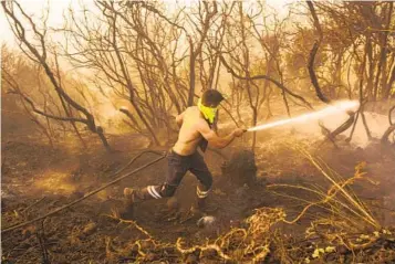  ?? EMRAH GUREL AP ?? A Turkish firefighte­r works to extinguish a forest fire in Beykoz, on the outskirts of Istanbul, Turkey, on Wednesday. Water-dropping planes and helicopter­s were also deployed to fight the blaze.