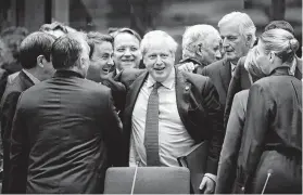  ?? Frank Augstein / Associated Press ?? British Prime Minister Boris Johnson, center, celebrates a new tentative Brexit deal on Thursday at an EU summit in Brussels.