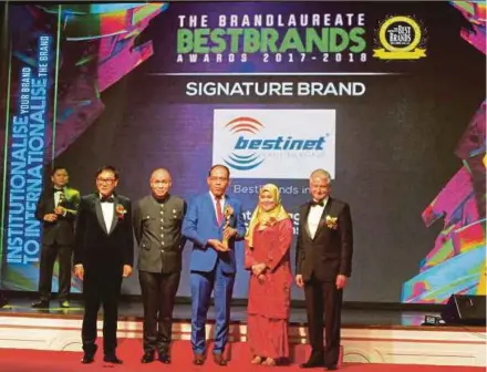  ??  ?? Bestinet Sdn Bhd chief executive officer Ismail Mohd Noor (in blue suit) receiving The BrandLaure­ate’s Signature Award for the Best Brand in Informatio­n Technology in Kuala Lumpur on Thursday.