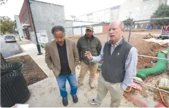  ?? STAFF PHOTO BY TIM BARBER ?? Developers Bobby Joe Adamson, left, and Chris Curtis, right, stand with Jeffery Adamson, back center, as they talk about their new four-story building that will be erected at the corner of M.L. King Boulevard and Douglas Street.