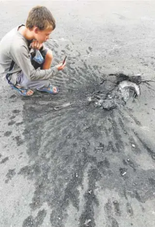  ?? // ABC ?? A la izquierda, equilibris­mo en las vías ferroviari­as de acceso a los campos de concentrac­ión. Sobre estas líneas, imagen de un niño que a su vez fotografía el impacto de un proyectil en Ucrania HOLOCAUSTO Y GUERRAS, TODO UN CLÁSICO