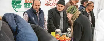  ??  ?? Foto: Imago An der Gemüseausg­abestelle in Ankara stehen die Menschen in langen Schlangen an, um Tomaten, Zwiebeln und anderes Gemüse zu günstigere­n Preisen zu kaufen.